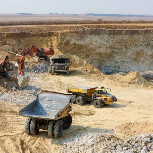 Dump trucks and excavators transporting manganese - manganese mining and processing
