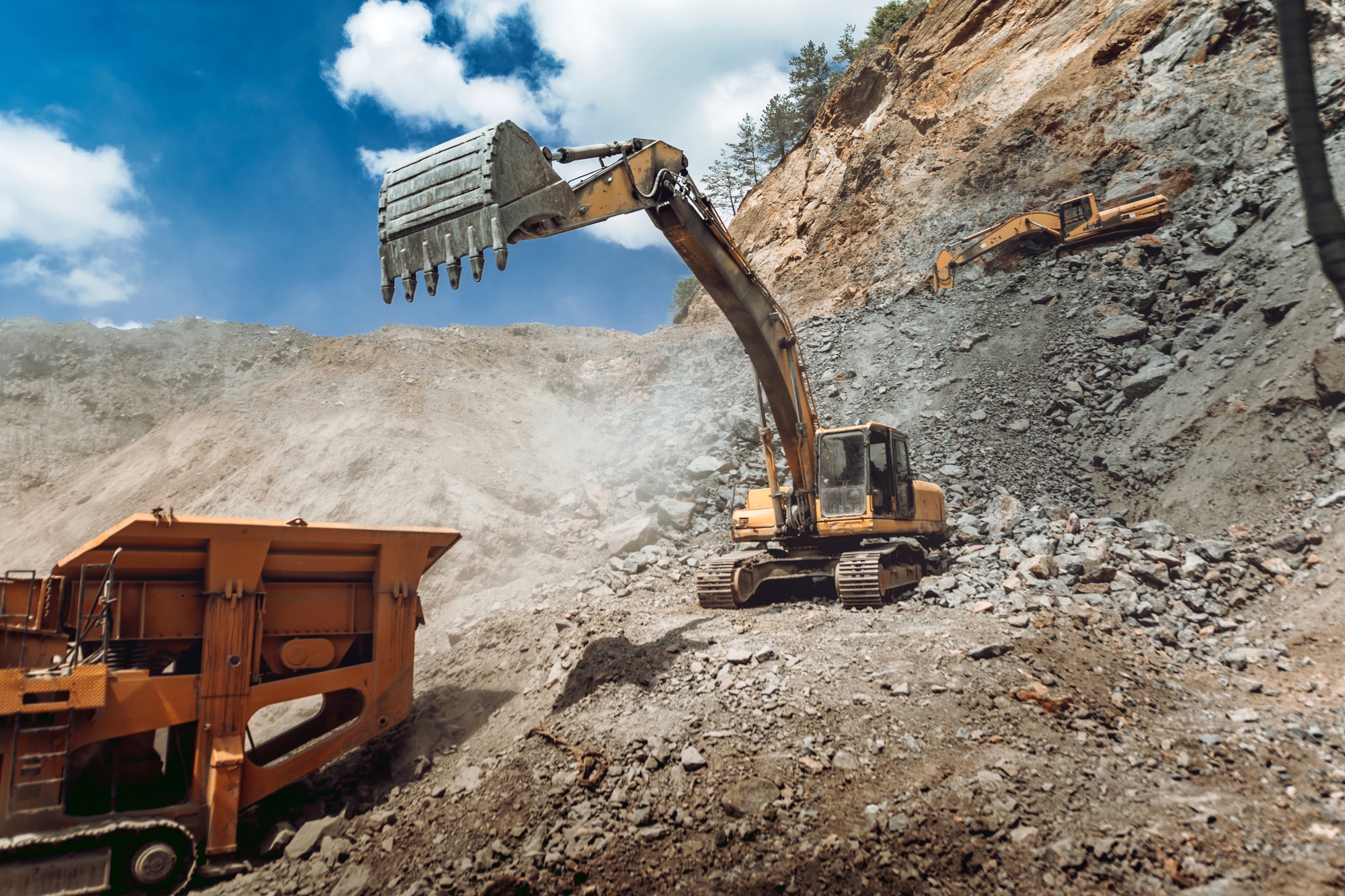 Track type excavator loading granite rock or ore quarry crushing and sorting plant